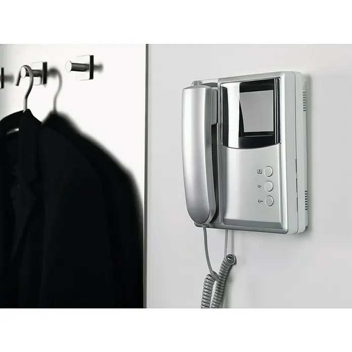 Tesa Cinta de doble cara Powerbond Ultra Fuerte - 19 mm x 1,5 m, Transparente - Un portero automático moderno con un acabado plateado y pantalla montado en una pared blanca.