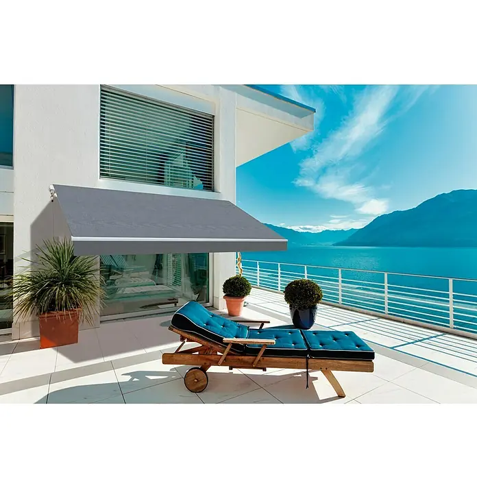 SmartSun Toldo de brazos extensibles Original Kit Acrílico - Gris, Ancho: 4 m, Caída: 2,5 m - Toldo retráctil gris en un patio con una tumbona y vistas al lago.