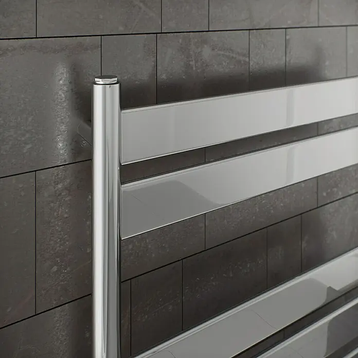 Ximax Designheizkörper C6 - B x H: 500 x 1.200 mm, Wärmeleistung bei Vorlauftemperatur von 75 °C (D: 50): 282 W - Nahaufnahme einer modernen, verchromten Handtuchheizung vor einer grauen Steinwand. Das glänzende Design des Heizkörpers sticht hervor.
