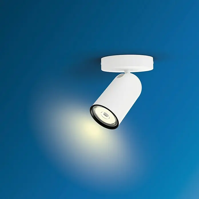 Philips Foco de pared Pongee - 10 W, L x An x Al: 8,2 x 13,8 x 10 cm, Blanco, GU10 - Primer plano de una lámpara de techo blanca con un haz de luz dirigido sobre un fondo azul.