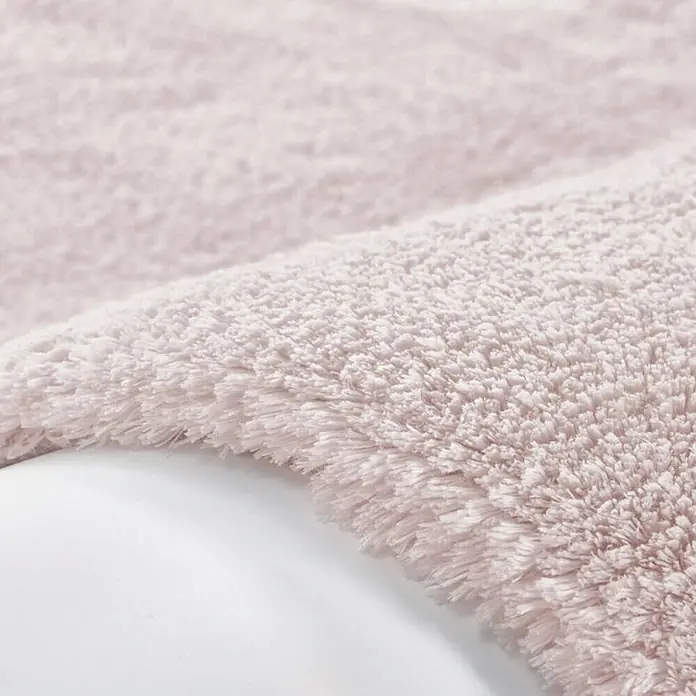 Kayoom Hochflorteppich Bali - Puderrosa, 230 x 160 cm, 100 % Polyester - Nahaufnahme eines rosafarbenen, flauschigen Badteppichs, der eine weiche und luxuriöse Textur für das Badezimmer bietet.