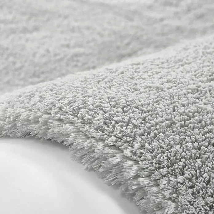 Kayoom Hochflorteppich Bali - Silbergrau, 150 x 80 cm, 100 % Polyester - Detailansicht eines grauen, flauschigen Badteppichs. Der Teppich hat eine weiche Textur und eine helle, neutrale Farbe.