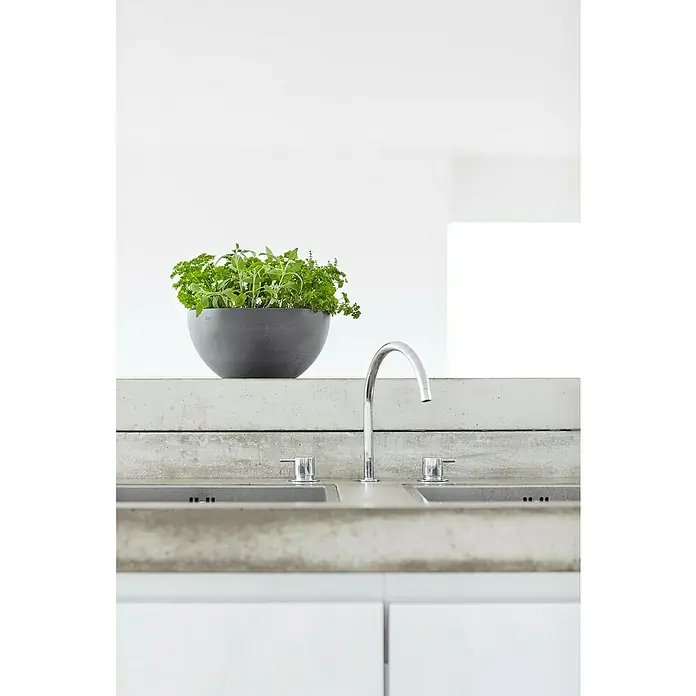 Ecopots Brussels Pflanzschale rund - Außenmaß (Ø x H): 25 x 12 cm, Kunststoff, Grau - Moderne Küchenspüle mit Armatur, eingelassen in eine Betonarbeitsplatte, neben einem Topf mit frischen Kräutern als dekoratives Element.