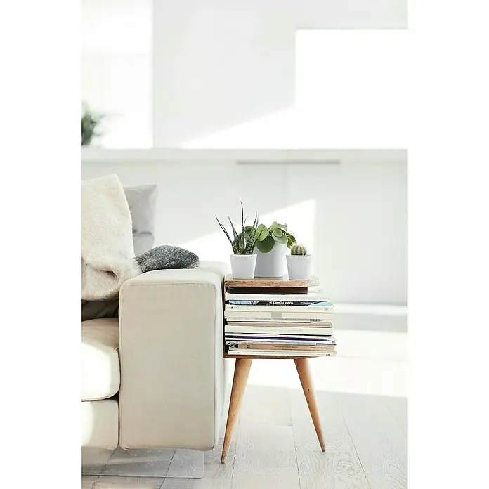 Ecopots Amsterdam Pflanztopf Mini - Außenmaß (Ø x H): 13 x 11,4 cm, Kunststoff, Weiß - Nahaufnahme eines Wohnzimmers mit einem Beistelltisch aus Büchern und Pflanzen, der neben einem cremefarbenen Sofa steht.
