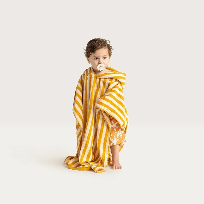 Swim Essentials Badeponcho - Baumwolle, Gelb-Weiß - Ein süßes Kind in einem gelb-weiß gestreiften Badeponcho mit Kapuze und Schnuller im Mund.