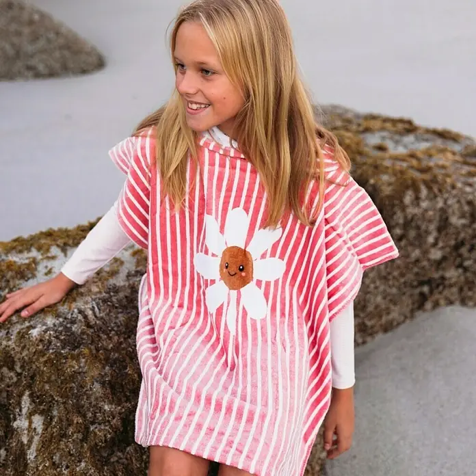 Swim Essentials Badeponcho - Baumwolle, Rot-Weiß - Mädchen mit einem gestreiften Strandponcho mit einer großen Gänseblume.