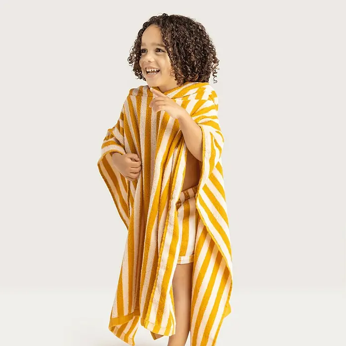 Swim Essentials Badeponcho - Baumwolle, Gelb-Weiß - Fröhliches Kind mit gestreiftem Kapuzenhandtuch. Das Handtuch in Gelb und Weiß ist perfekt für den Strand oder Pool.