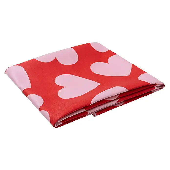 Swim Essentials Handtuch - 135 x 65 cm, Rot-Weiß - Gerolltes Tuch mit rotem Hintergrund und rosa Herzen. Das Tuch ist mehrlagig und hat ein verspieltes Muster.