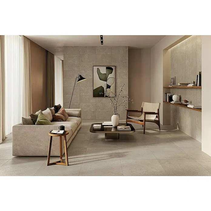 Atlas Concorde Solution Feinsteinzeugfliese Lunastone - 60 x 60 cm, Ash, Matt - Gemütliches Wohnzimmer mit beigem Sofa, Holztisch und Kunstwerk an der Wand, das eine warme und einladende Atmosphäre schafft.