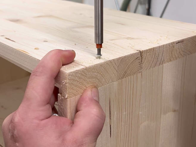 2 Holzplatten werden im rechten Winkel zusammengeschraubt