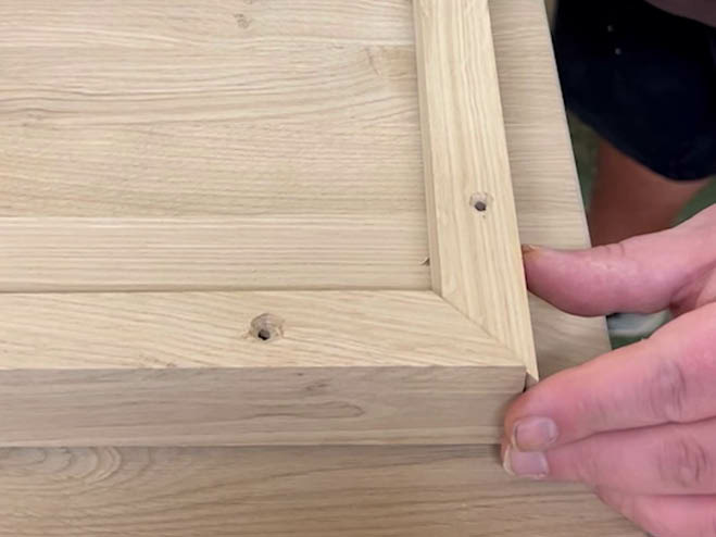 2 Holzleisten werden an der Unterseite der Holzplatte im 45-Grad-Winkel angeschraubt