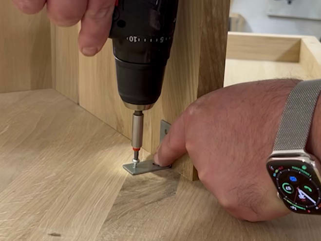 Die Holzbeine werden an die Tischplatte geschraubt