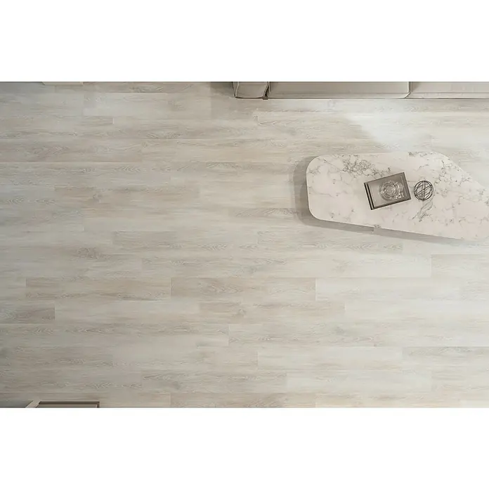 Laminado Ebro - 1.200 x 191 x 8 mm, AC5 - Textura de suelo de madera clara con una mesa de centro y un libro encima. Perfecto para un diseño interior moderno y elegante.