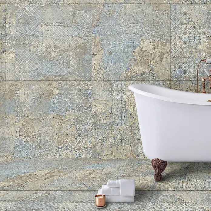 Feinsteinzeugfliese Carpet Natural - 100 x 100 cm, Vestige, Matt - Das Bild zeigt großformatige Keramikfliesen mit einem verschlungenen Vintage-Muster in einem Badezimmer-Setup mit Badewanne und Handtüchern.