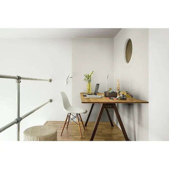 Bruguer Elegance Pintura para paredes - Blanco niebla, Mate, 4 l - Escena de espacio de trabajo luminoso con un escritorio de madera, un ordenador portátil, decoraciones y una silla elegante que crea un ambiente creativo y moderno.