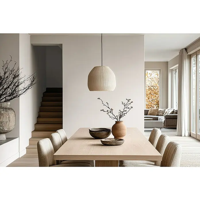 Bruguer Elegance Pintura para paredes - Blanco piedra, Mate, 4 l - Elegante comedor con una lámpara colgante sobre una mesa de madera, complementado con decoraciones estilosas y sillas cómodas.