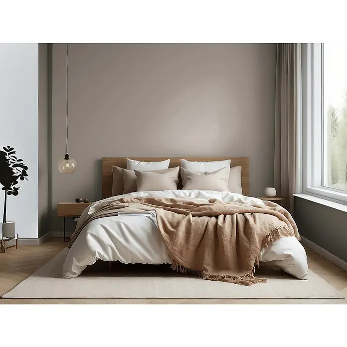 Bruguer Elegance Pintura para paredes - Marrón tierra, Mate, 4 l - Un dormitorio acogedor con una cama grande con ropa de cama en tonos neutros y una alfombra clara. La iluminación crea un ambiente sereno.