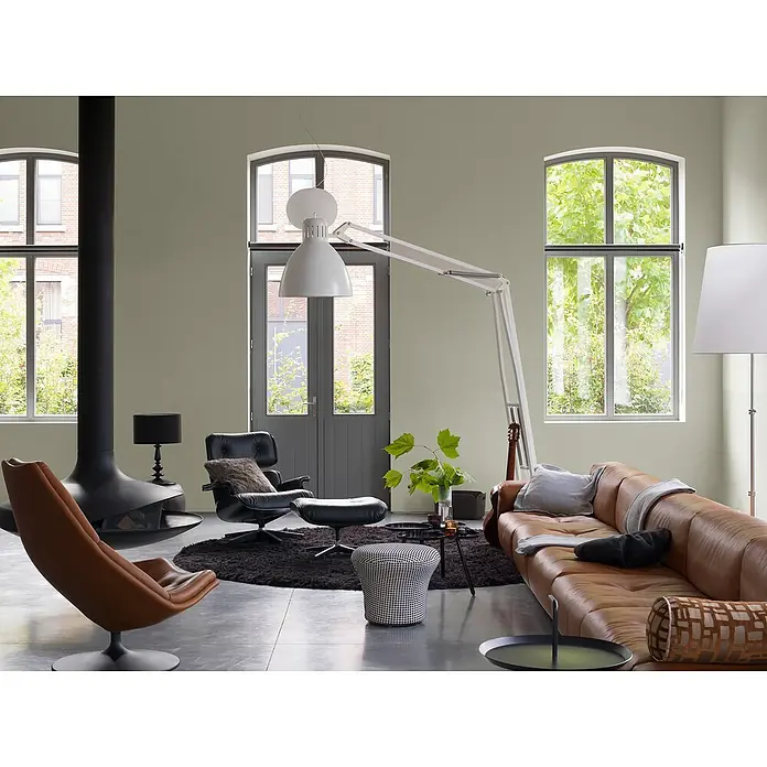 Bruguer Elegance Pintura para paredes - Verde oliva, Mate, 4 l - Salón con sofá de cuero, sillón de diseño, chimenea y lámpara grande. Interior luminoso y moderno con vista verde.