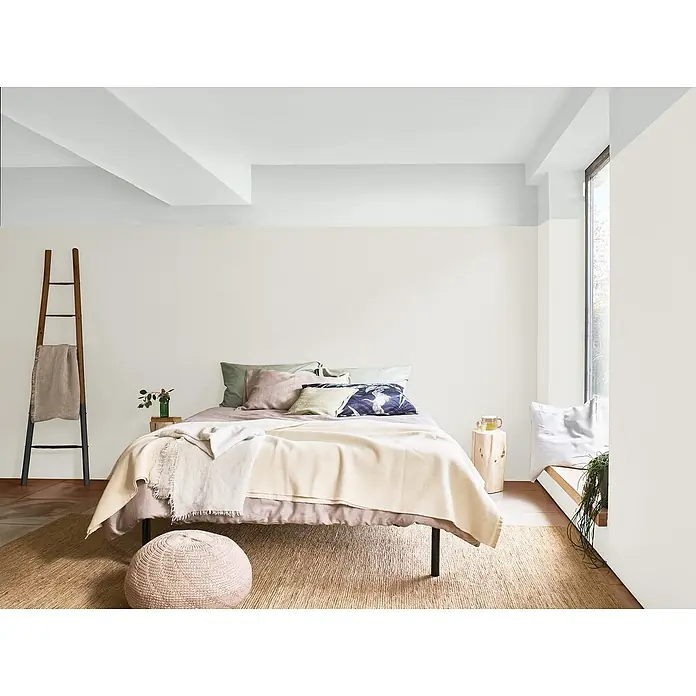 Bruguer Elegance Pintura para paredes - Blanco espuma, Mate, 4 l - Acogedor dormitorio con una escalera decorativa que sostiene una manta elegante, mejorando el ambiente acogedor y el estilo de la habitación.