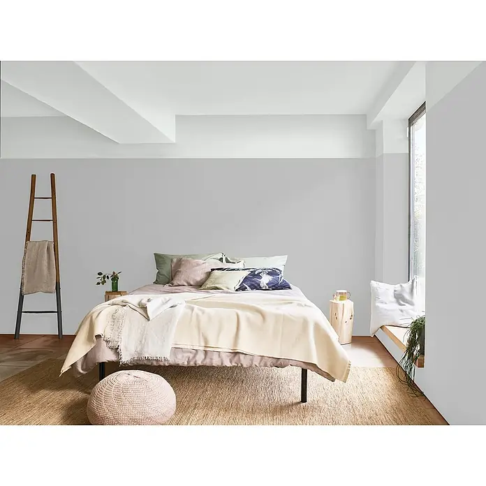 Bruguer Elegance Pintura para paredes - Gris piedra, Mate, 4 l - Acogedora habitación con alfombra clara, cama cómoda y una escalera de madera decorativa que aporta calidez y estilo al espacio.