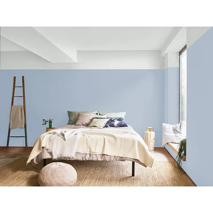 Bruguer Elegance Pintura para paredes - Azul bruma, Mate, 4 l - Acogedor dormitorio con paredes pintadas de azul, una alfombra clara y detalles naturales, creando un ambiente sereno y relajante.