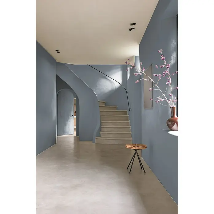 Bruguer Elegance Pintura para paredes - Gris sombra, Mate, 4 l - Una foto elegante de un interior, con una escalera elegante, un taburete pequeño y elementos florales en un jarrón.