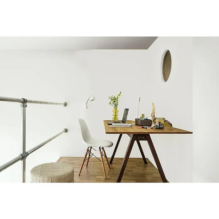 Bruguer Elegance Pintura para paredes - Blanco nube, Mate, 4 l - Oficina con escritorio de madera, portátil y decoraciones, más una silla blanca. Un espacio de trabajo elegante en un espacio luminoso.