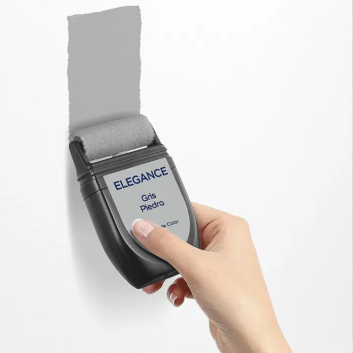 Bruguer Elegance Tester de pintura - Gris piedra, Mate, 30 ml - Primer plano de un rodillo de pintura Elegance, con pintura gris aplicada sobre una pared blanca.