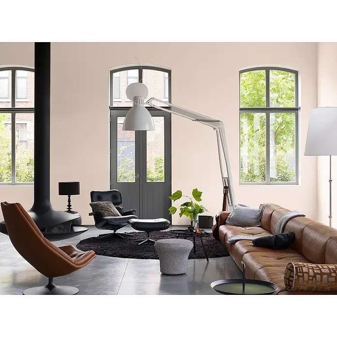 Bruguer Elegance Pintura para paredes - Rosa antiguo, Mate, 4 l - Salón con sofá de cuero marrón, sillones y chimenea moderna. Las paredes claras y las grandes ventanas crean un ambiente acogedor.