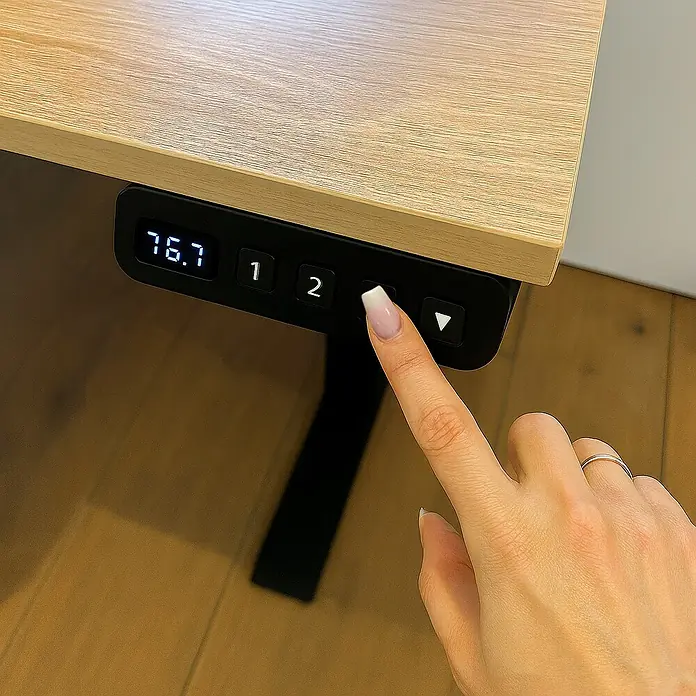 Schildmeyer Emmik Schreibtisch - L x B: 60 x 138 cm, Höhenverstellung: 72,7 cm - 117,2 cm, Weißeiche - Nahaufnahme eines höhenverstellbaren Schreibtisches mit digitaler Anzeige und Bedienfeld, auf dem ein Finger einen Knopf drückt.