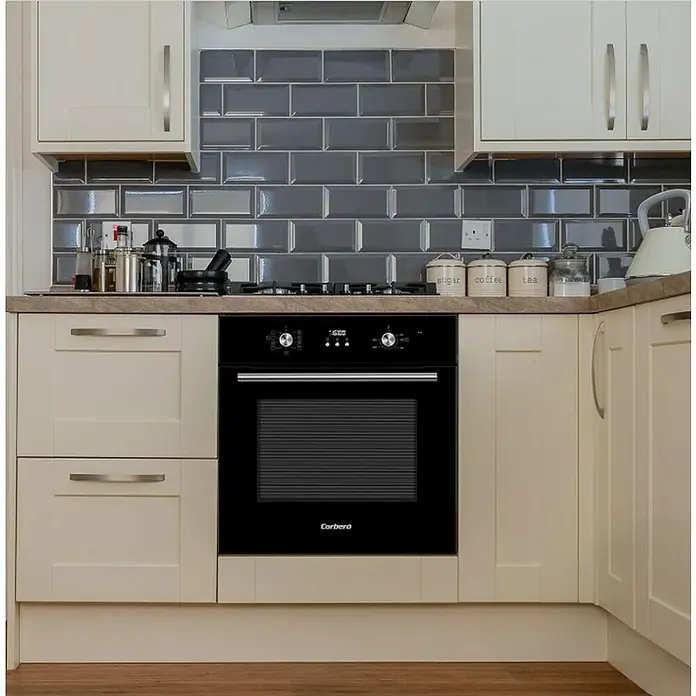 Corberó Horno empotrado CCHMD805N - Volumen horno: 70 l - Vista de la cocina con un horno Corbero negro, integrado en un mueble de cocina con armarios claros y azulejos grises.