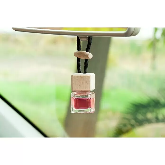 Ambientador de coche para colgar - Fresa, 8 sem. - Ambientador de coche de cristal cuadrado con líquido rosa y tapa de madera, colgando del espejo retrovisor.