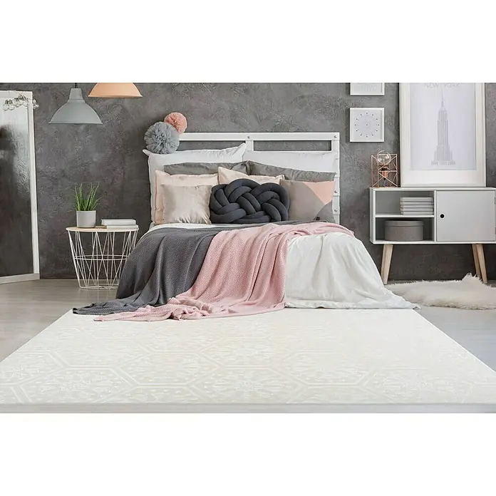 Kayoom Kurzflorteppich Monroe II - Weiß, 230 x 160 cm, 100 % Polyester - Nahaufnahme eines modernen Schlafzimmers mit einem eleganten, weißen Teppich mit geometrischem Muster, der den Raum aufwertet.