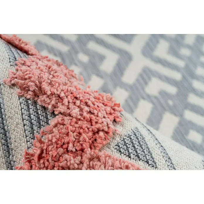 Kayoom Flachgewebeteppich Ethnie - Grau/Rot, 230 x 160 cm, 100 % Baumwolle - Nahaufnahme eines dekorativen Teppichs mit rosa Zotteldetails und einem geometrischen Muster in Grau- und Weißtönen, der Textur und Design hervorhebt.