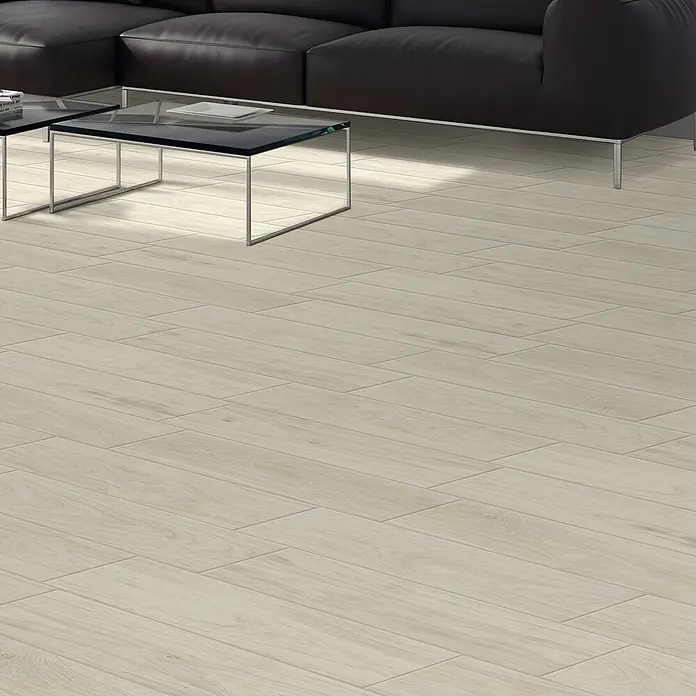 Steingutfliese Legno Natural Avorio - 60 x 15 cm, Beige, Matt - Nahaufnahme des hellen Laminatbodens mit Holzstruktur in einem modernen Wohnzimmer, ergänzt durch ein schwarzes Sofa und Glastische.