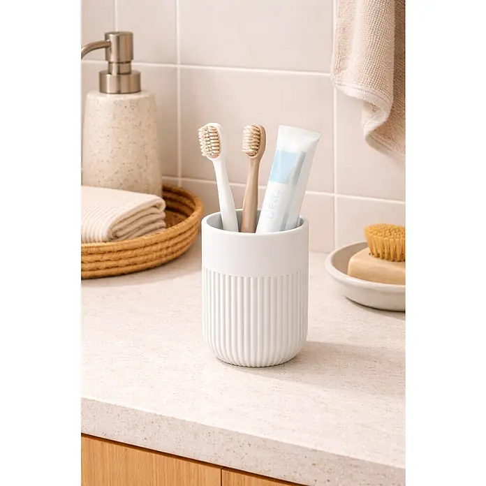Spirella Gino Portacepillos - L x An x Al: 7 x 7 x 11 cm, Diámetro: 7 cm, Plástico, Blanco - Soporte para cepillos de dientes blanco con dos cepillos de dientes y pasta de dientes en un lavabo en un baño.