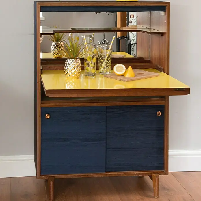 D-c-fix Lámina efecto madera Quadro - 150 x 67,5 cm, Azul noche, Autoadhesivo - Imagen de un elegante mueble bar moderno de mediados de siglo con encimera amarilla, puertas azules y parte trasera con espejo, que desprende encanto vintage.