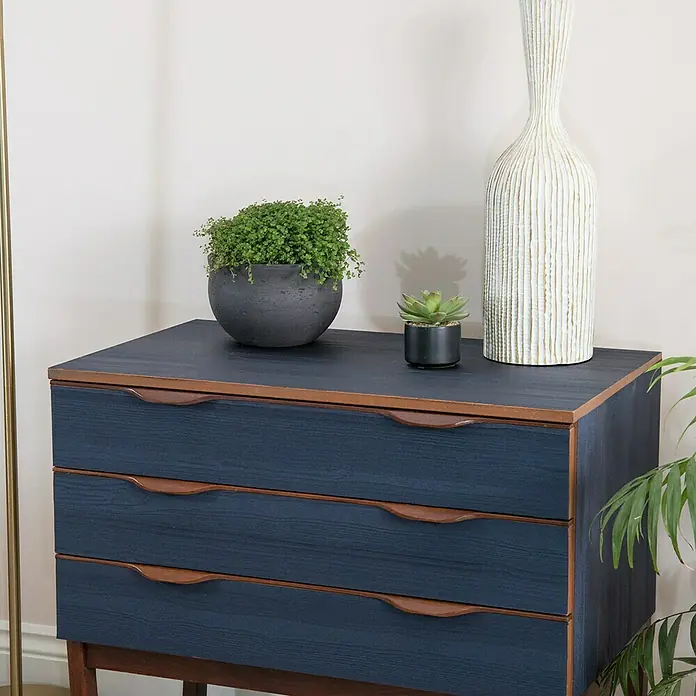 D-c-fix Lámina efecto madera Quadro - 150 x 67,5 cm, Azul noche, Autoadhesivo - Elegante cómoda de tres cajones con aspecto de madera azul, adornada con plantas y un jarrón.