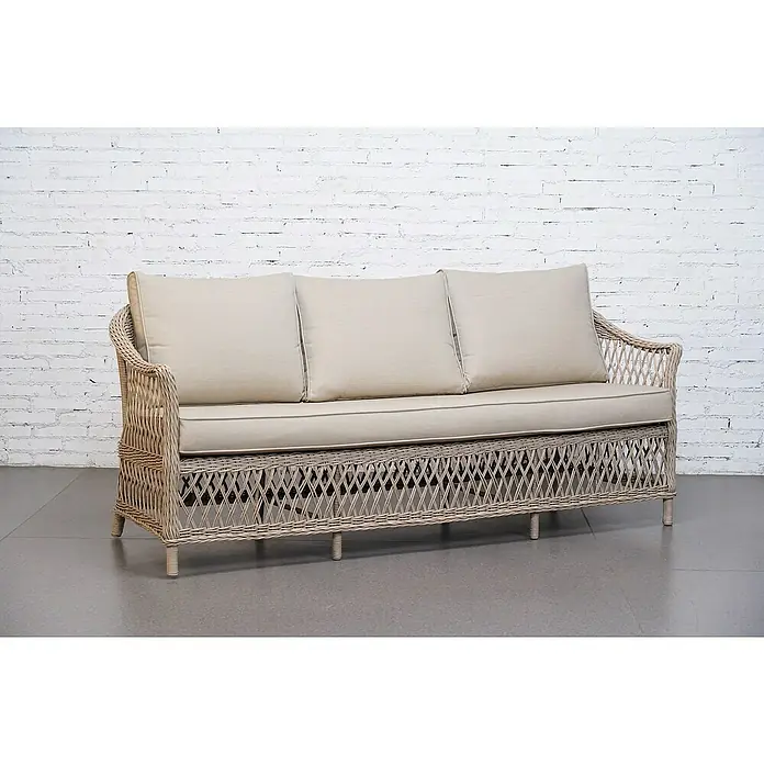 Sunfun Conjunto de muebles Soraya - 4 pzs., Ratán sintético/Aluminio/Poliéster, Beige/Gris - Esta imagen muestra un elegante sofá de ratán con cojines beige claro contra una pared de ladrillo blanco, irradiando confort y estilo.