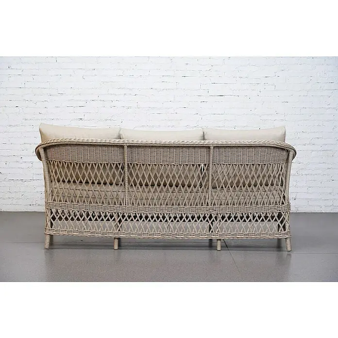 Sunfun Conjunto de muebles Soraya - 4 pzs., Ratán sintético/Aluminio/Poliéster, Beige/Gris - Vista trasera de un sofá tejido de color claro con tres cojines claros, sobre un fondo de pared de ladrillo blanco.