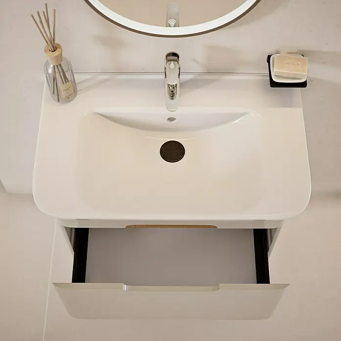 VitrA Sento Badmöbel-Set Sento - 80 cm, Hellgrau, Griffmulde - Bild eines modernen weißen Waschtischs mit einer offenen Schublade, ergänzt durch Armaturen und Accessoires, die das elegante Design hervorheben.