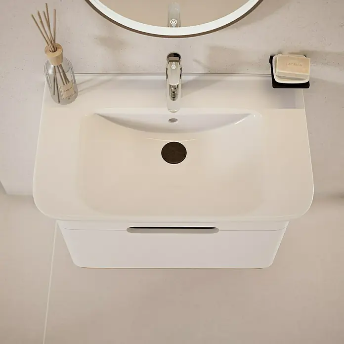 VitrA Sento Badmöbel-Set Sento - 80 cm, Weiß, Griffmulde - Nahaufnahme eines modernen weißen Waschbeckens mit Armatur, Seifenspender und Duftstäbchen im Badezimmer.