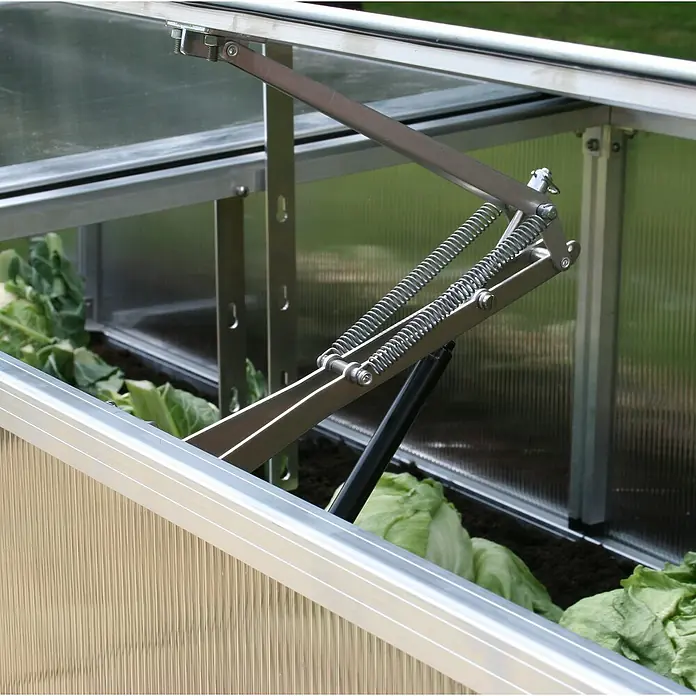 KGT Automatischer Fensteröffner - Passend für: KGT Frühbeete - Nahaufnahme eines Frühbeets mit hochgeklapptem Deckel, der durch Federmechanismen gehalten wird.