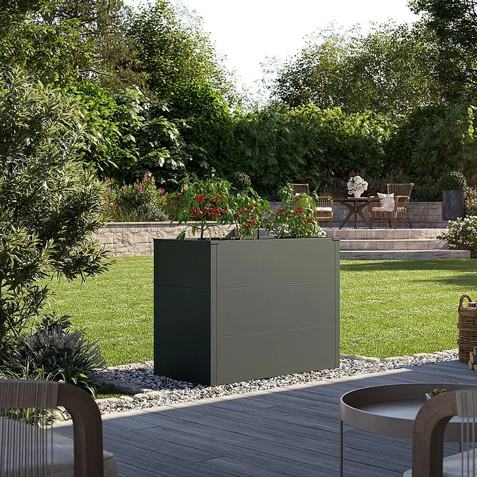 KGT Hochbeet UrbanGrow M - 101 x 51 x 78 cm, Metall, Anthrazit-grau - Der graue, moderne Pflanzkasten ist mit Pflanzen bepflanzt und befindet sich in einem Garten mit Rasen.