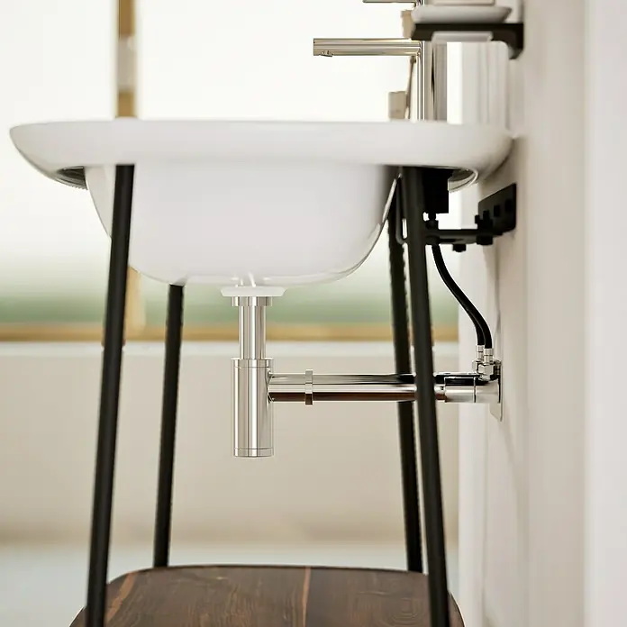 VitrA Plural Badmöbel-Set - Gesamtbreite Badmöbel: 99,5 cm, Weiß/Eiche Dunkel/Schwarz, Glänzend, 3 -tlg. - Nahaufnahme eines modernen Waschbeckens mit Chromarmaturen und schwarzen Metallbeinen vor einem hellen Hintergrund.