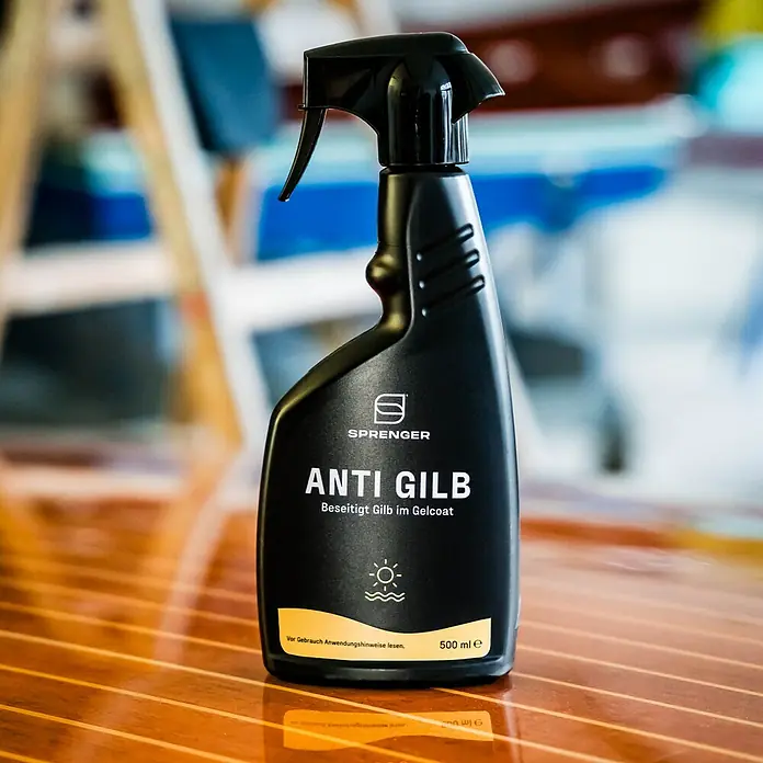Sprenger Gelcoat Reiniger Anti Gilb - 500 ml - Nahaufnahme einer schwarzen Sprühflasche "Sprenger Anti Gilb" auf einem Holztisch.
