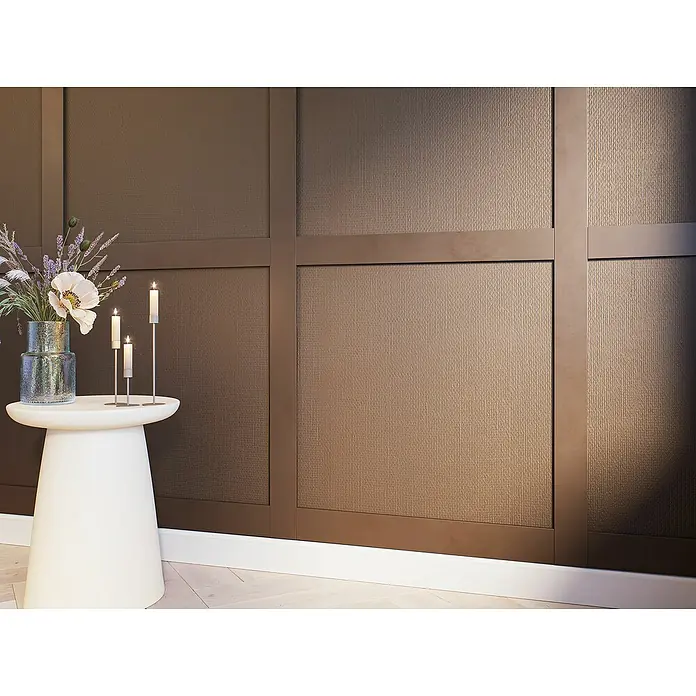 Wandleiste Set - Fläche 130x130cm, Weiß, MDF, Höhe: 1,3 cm, Breite: 6,3 cm - Elegantes Interieur mit weißen Beistelltisch, Kerzen und Blumenvase vor einer braunen Wandverkleidung, die eine warme und stilvolle Atmosphäre schafft.