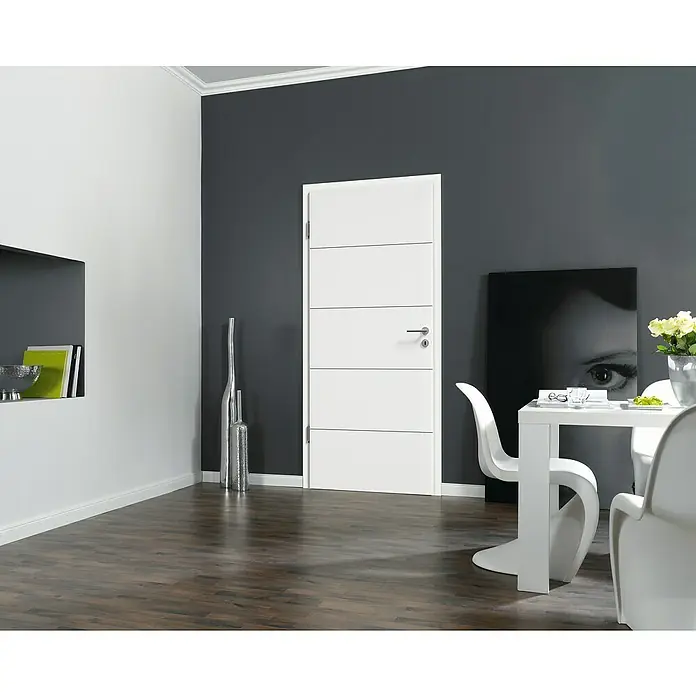 Kilsgaard Zimmertür 14/14 - 735 x 1.985 mm, DIN Anschlag: Links, Weiß lackiert, ähnlich RAL 9010, Röhrenspan, Schwarze V-Fugen - Ein modernes Interieur mit einer weißen Innentür mit horizontalen Linien. Das Design harmoniert perfekt mit der dunklen Wand und dem hellen Boden.