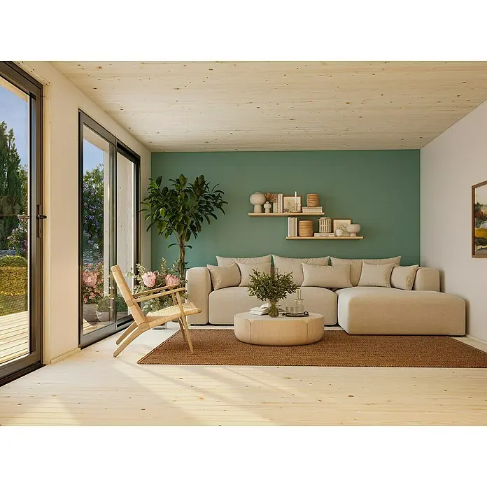 Palmako Gartenhaus Johanna Nordic Plus - Außenmaß inkl. Dachüberstand (B x T): 562 x 448 cm, Holz, Natur unbehandelt - Wohnzimmer mit großem Sofa, Holzstuhl und Pflanzen. Der Raum ist hell und freundlich gestaltet.