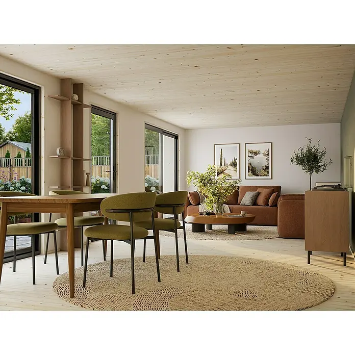 Palmako Gartenhaus Johanna Nordic Plus - Außenmaß inkl. Dachüberstand (B x T): 901 x 448 cm, Holz, Natur unbehandelt - Helle, moderne Wohnung mit Esstisch und grünen Stühlen im Vordergrund, Sofa und Kunst im Hintergrund. Gemütliches Ambiente.